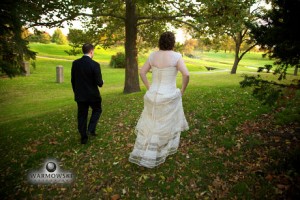 Bride and groom from behind walk in park