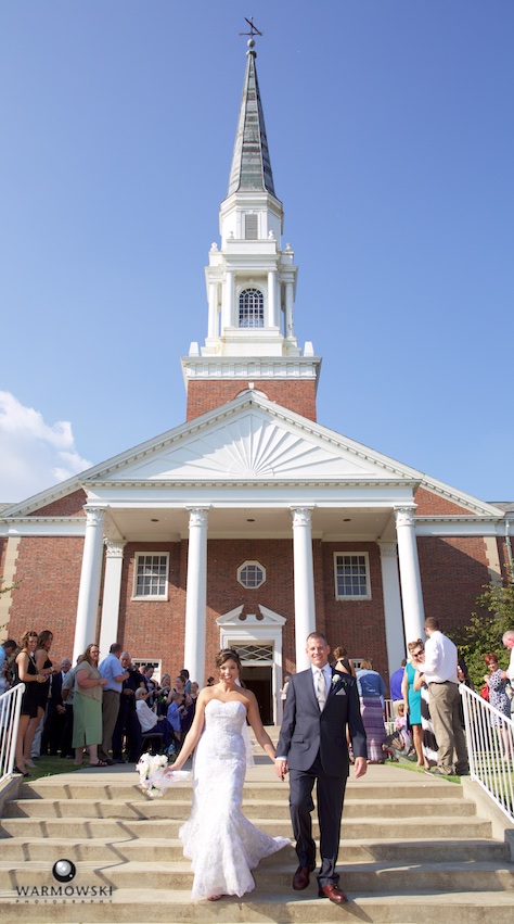 Adria and Jeremy walk through bubbles at MacMurray College's Annie Merner Chapel. Wedding photography by Steve & Tiffany Warmowski.