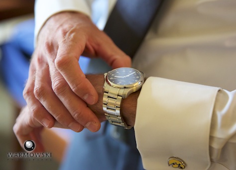 Daniel checks the time, getting ready at the Inns of Geneva National. Wedding photography by Steve & Tiffany Warmowski