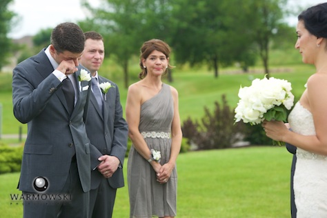 Daniel reacts as Emi comes down the aisle. Wedding photography by Steve & Tiffany Warmowski