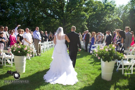 Amy walks down the aisle with her father at her wedding in rural Springfield. Amy's parents Mark and Susan gave the couple a beautiful outdoor wedding right in their yard. Wedding photography by Tiffany & Steve of Warmowski Photography.