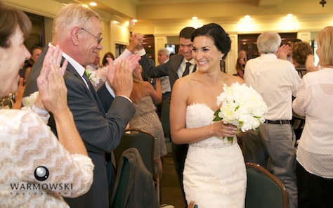 Emi & Daniel walk in to start the reception at Geneva National Golf Club. Wedding photography by Steve & Tiffany Warmowski