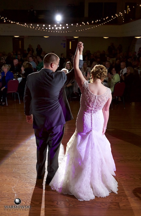 Amy & Ryan recognize applause at the end of their first dance. Wedding reception at the Hoogland Center for the Arts in Springfield featuring live wedding band Fun DMC. Wedding photography by Tiffany & Steve of Warmowski Photography.