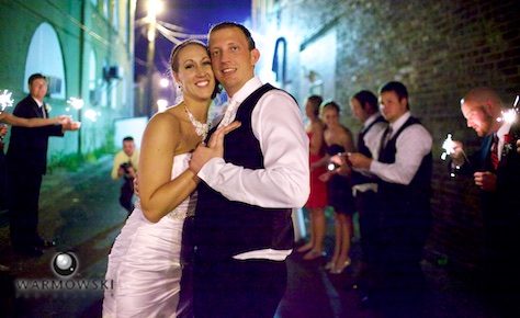 Amber & Ryan end the 4th of July night with sparklers, outside of reception hall Hamilton's 110 North East. Wedding photography by Steve & Tiffany Warmowski